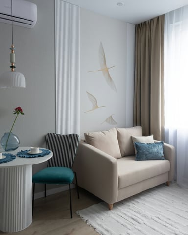Light beige apartment with cream sofa, bird wall art and sheer curtains
