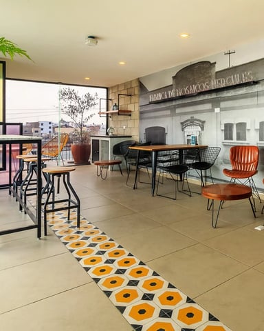 Rooftop common area with industrial-style seating and Guadalajara mural