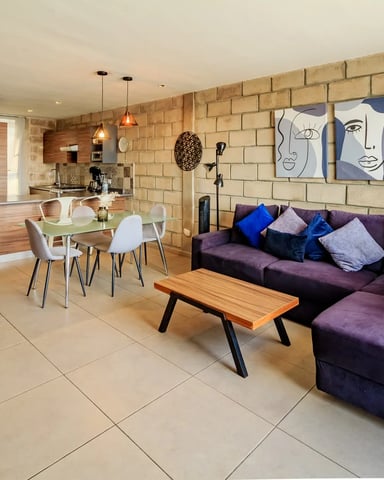 Sala y comedor de planta abierta con pared de ladrillo expuesto y arte facial
